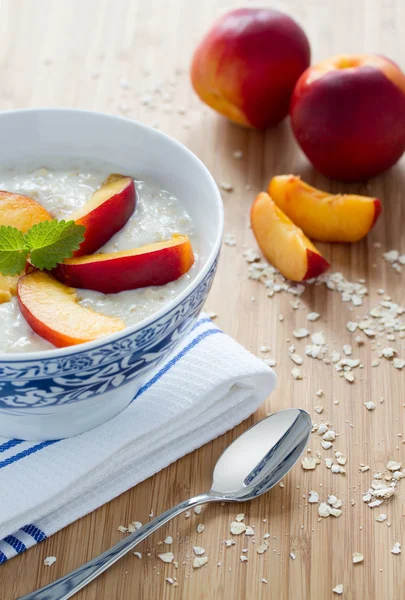 Oatmeal porridge with fresh nectarines — Stock Photo, Image
