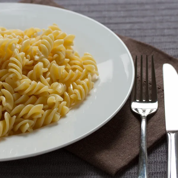 Een bord met gekookte pasta fusilli — Stockfoto