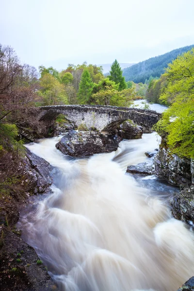 Floden och bron i berglandskap — Stockfoto