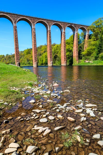 Flodbädden med gamla bron i bakgrunden — Stockfoto