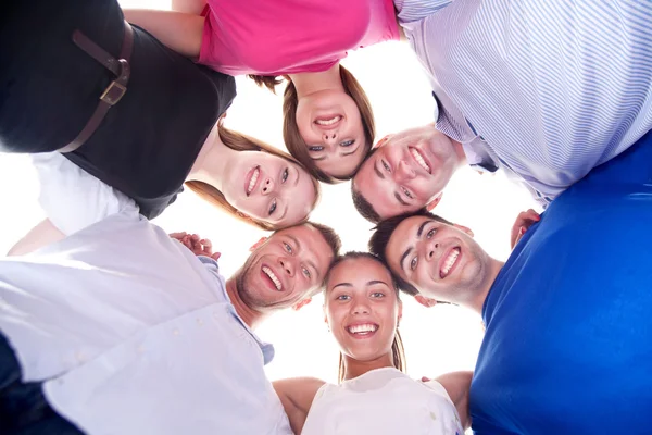 Unga glada vänner med huvuden tillsammans i cirkel — Stockfoto