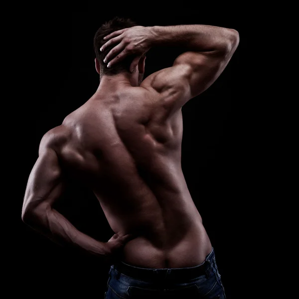 Strong athletic man on dark background — Stock Photo, Image