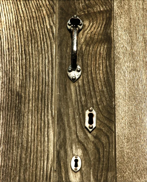 Houten deur met handvat en sleutelgaten — Stockfoto