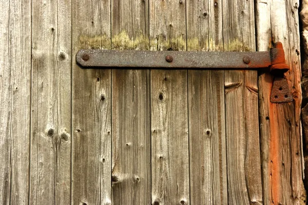 Porta de madeira lisa com dobradiça enferrujada — Fotografia de Stock