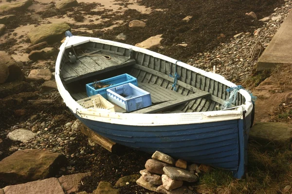 Лодка с веревками на берегу — стоковое фото
