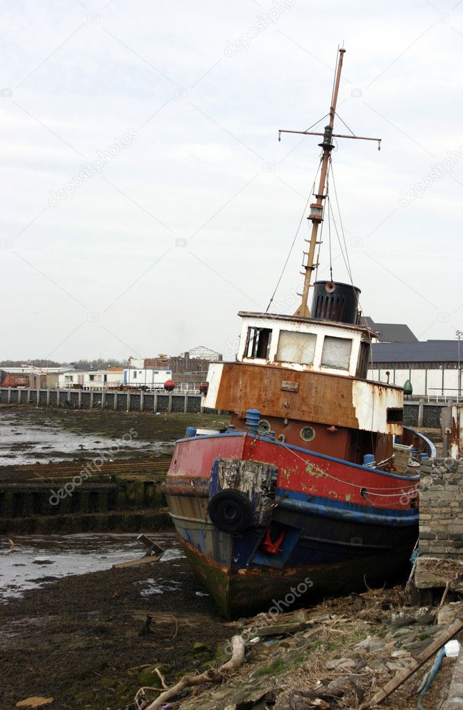 Old tug beached on the quayside