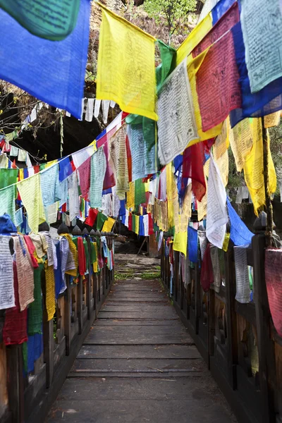 COLOURFUL PRAYER FLAGS AND A WOODEN BRIDGE IN BHUTAN — Stock Photo, Image