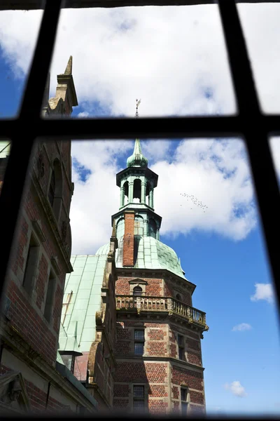 Tower of Frederiksborg Slot castle in Hillerod, Denmark, seen through an old window — Stock Photo, Image