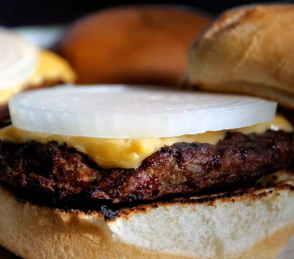 Чизбургер на гриле с луковым ломтиком — стоковое фото