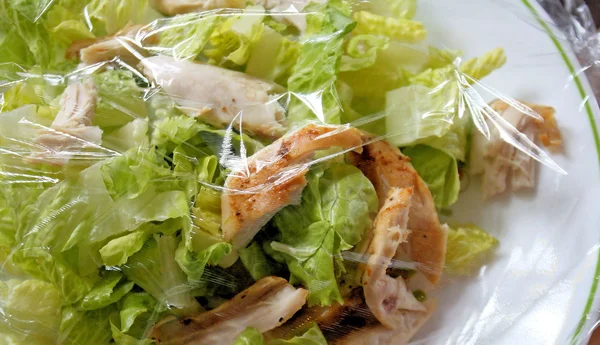 Куриный салат, покрытый пластиковой оберткой для свежести — стоковое фото