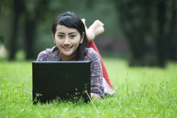 Smiling asian woman with laptop — Stock Photo, Image