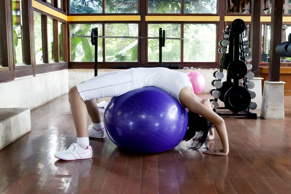 Женщина, упражняющаяся с швейцарским мячом — стоковое фото