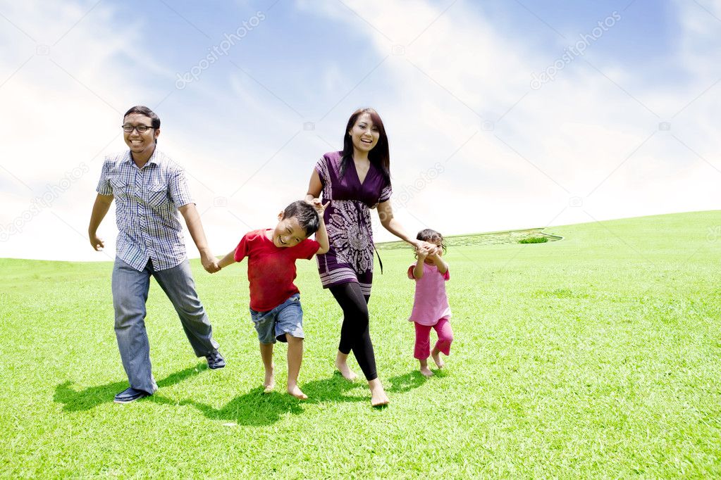 Happy asian family in meadow