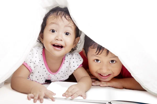Roztomilý sourozenci pod dekou — Stock fotografie