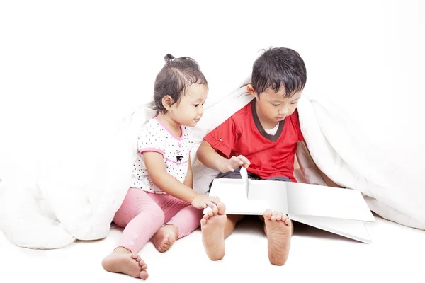 Азиатские братья и сестры читают книгу — стоковое фото