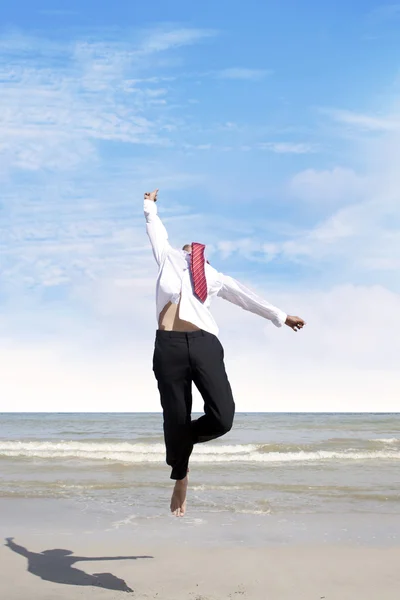 Empresario saltando en la playa — Foto de Stock