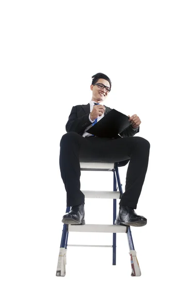 Businessman working on ladder — Stock Photo, Image
