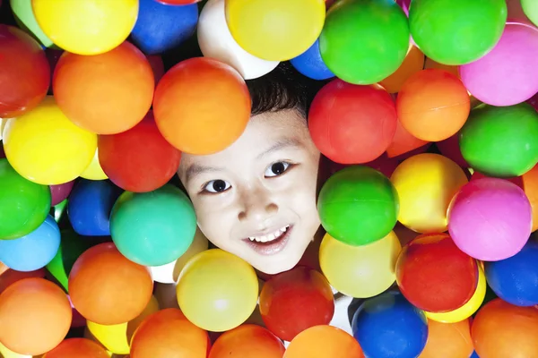 Glad pojke med färgglada bollar — Stockfoto