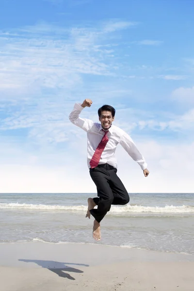 stock image Success bussinessman jumps at beach