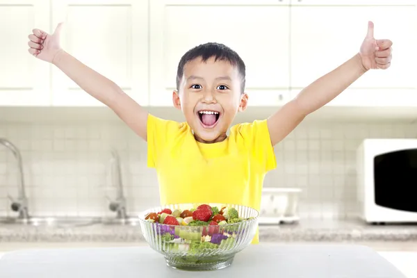 Довольный ребенок с салатом — стоковое фото