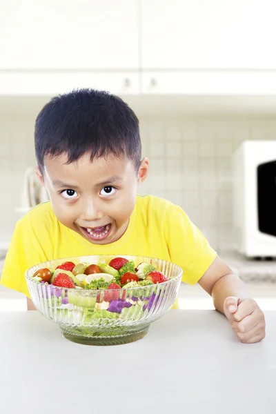 Criança faminta come salada — Fotografia de Stock