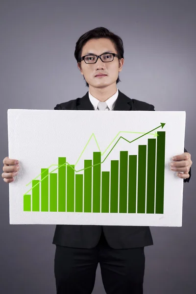 Businessman with green business statistics — Stock Photo, Image