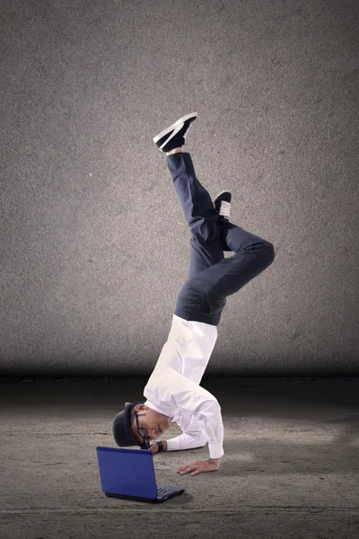 Hombre de negocios breakdancing con portátil — Foto de Stock