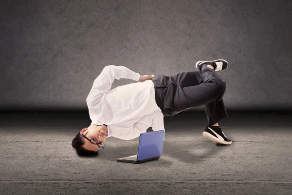 Businessman breakdancing with laptop — Stock Photo, Image