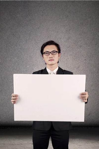 Businessman holding blank banner — Stock Photo, Image