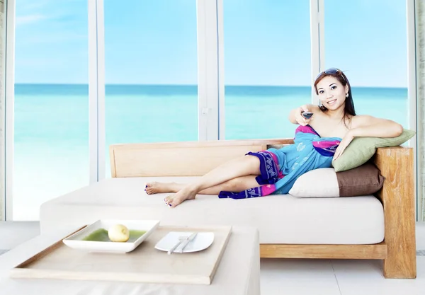 Femme asiatique regarder la télévision par la plage — Photo