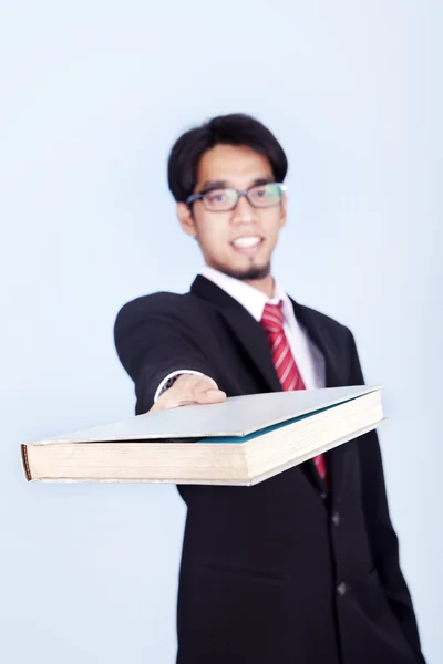 Empresário dando livro — Fotografia de Stock