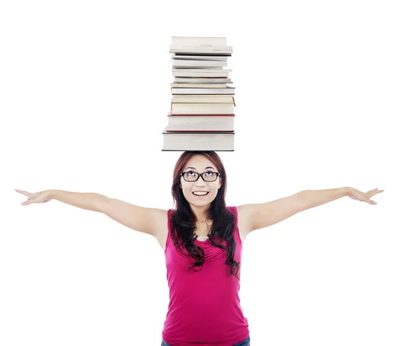Student med trave böcker på hennes huvud — Stockfoto