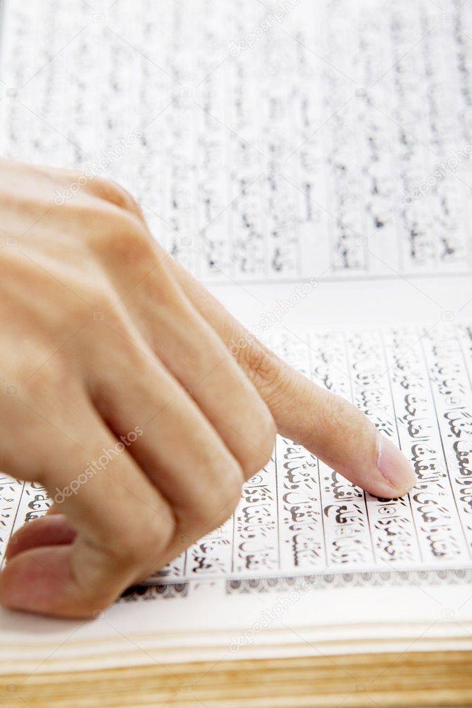 Hand pointing at paragraph of quran