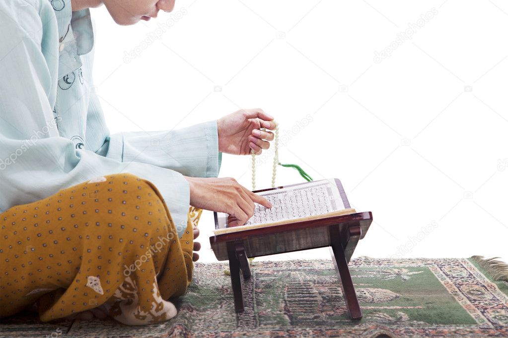 Asian Muslim reading Koran in Ramadan