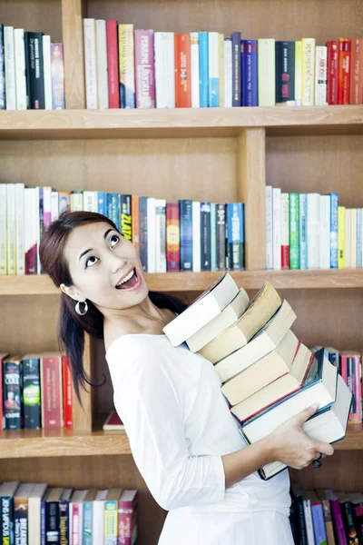 Kvinna som bär högen av böcker — Stockfoto