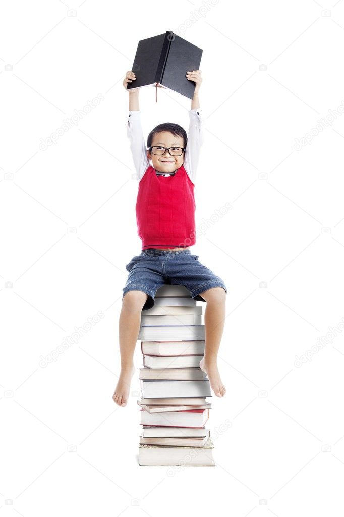 Asian student sitting on stack of books
