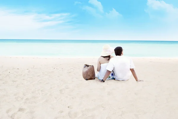 Пара, сидящая вместе на пляже — стоковое фото