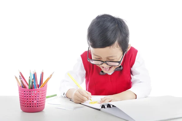 Happy pupil drawing with crayons — Stock Photo, Image
