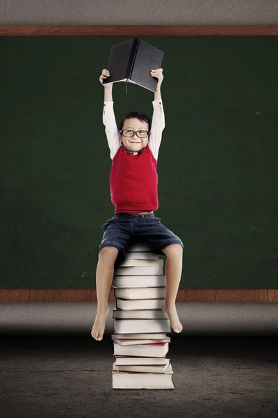 Chytrý student sedící na knihách — Stock fotografie