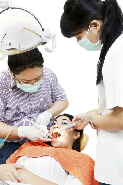 Азиатский дантист с ассистентом и пациентом — стоковое фото