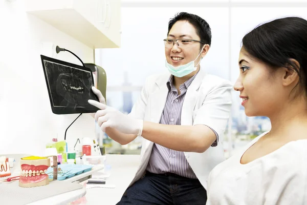 Азиатский стоматолог с рентгеном и пациентом — стоковое фото