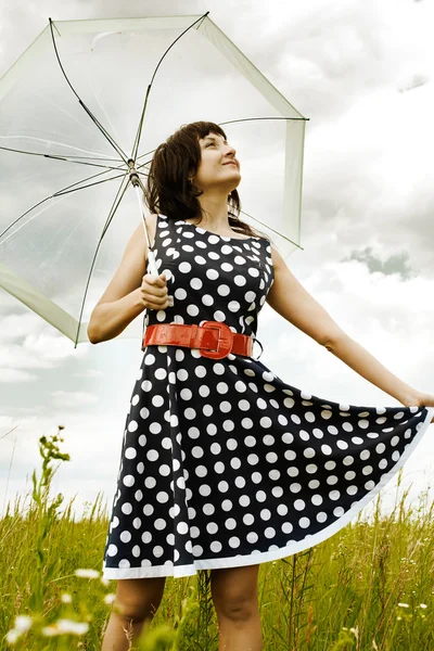 Happy young girl with umbrella in the field — Stock Photo, Image