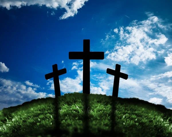 Silhouette von drei Kreuzen auf einem Hügel Stockbild