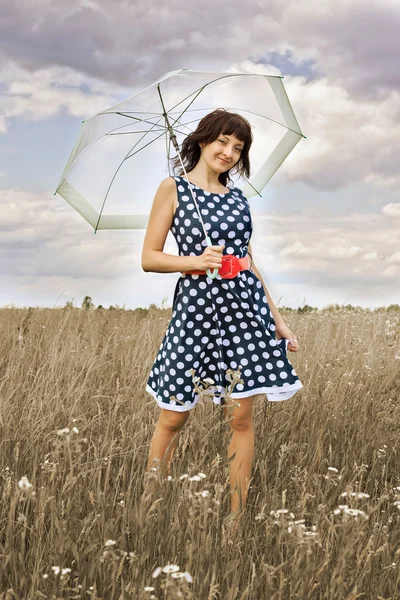 Happy young girl with umbrella in the field — Stock Photo, Image