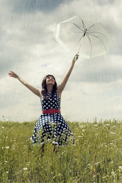 Chica joven feliz con paraguas en el campo Imagen De Stock