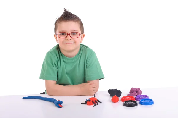 Young boy playing with modeling clay — Stock Photo, Image