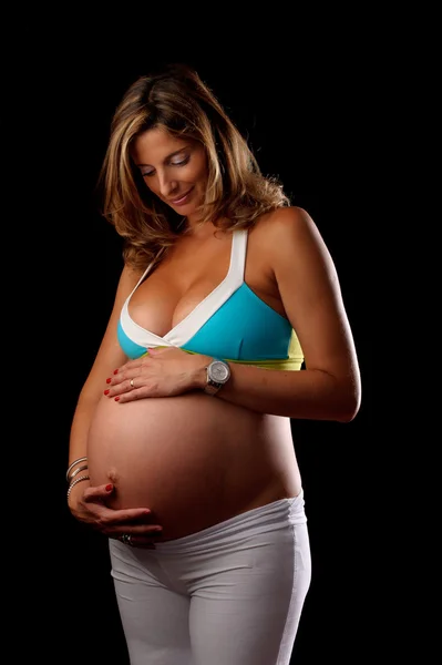 Pregnant woman looking and holding her belly — Stock Photo, Image