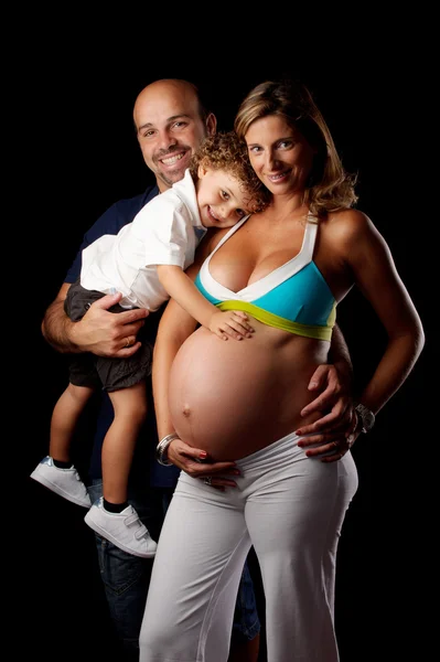 Lycklig familj med gravid kvinna i studio — Stockfoto