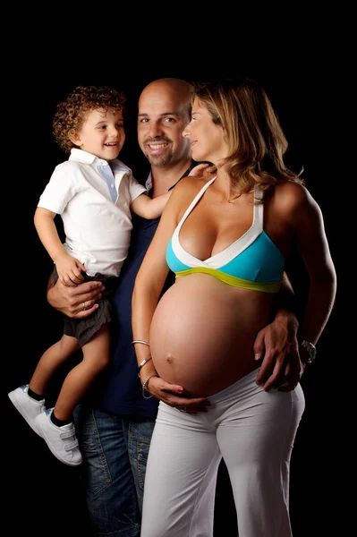 Gelukkige familie met zwangere vrouw in studio — Stockfoto