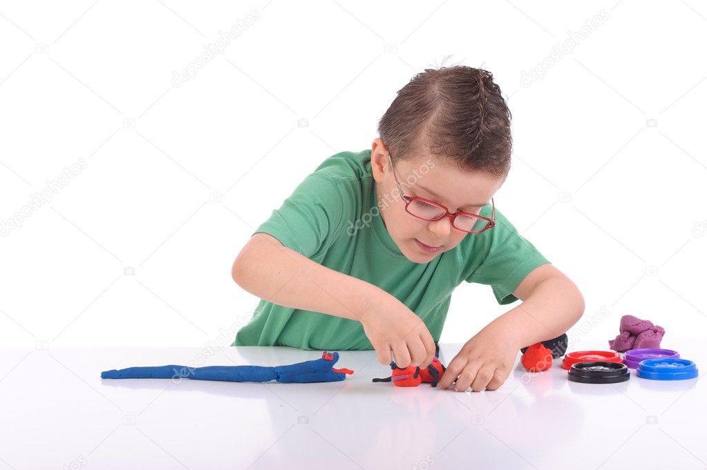 Young boy playing with modeling clay